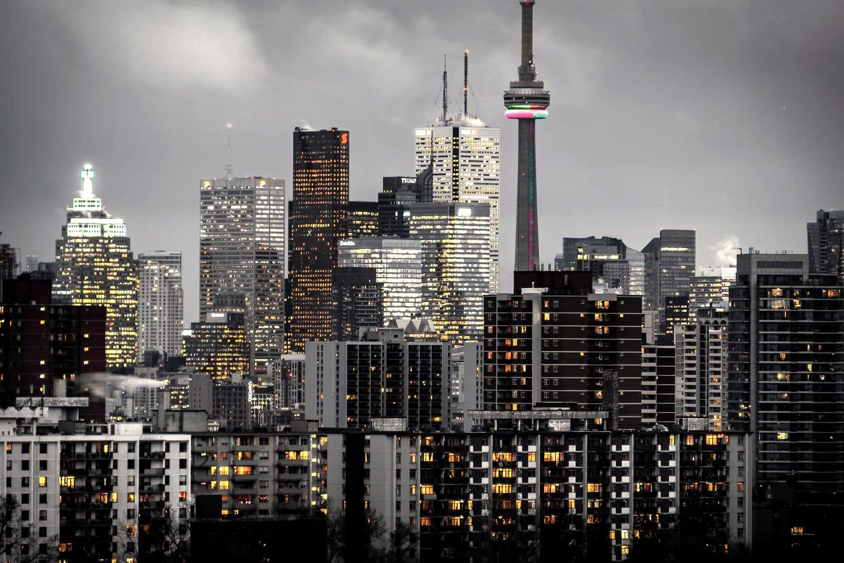 The Toronto skyline at dusk, lit office towers and the CN Tower above the downtown core